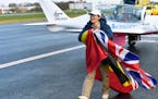 Belgium-British teenage pilot Zara Rutherford walks on the tarmac with a British and Belgian flag after landing her Shark ultralight plane at the Kort