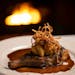 The bone-In pork chop, prepared with an herb brine, miso apple compote, and crispy onions at The Creekside Supper Club Thursday, Jan. 13, 2022 in Minn