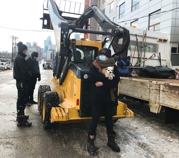 Protesters, including Nikki Carlson holding her dog, prevented regulatory services workers from nearing the North Loop encampment when the city had or