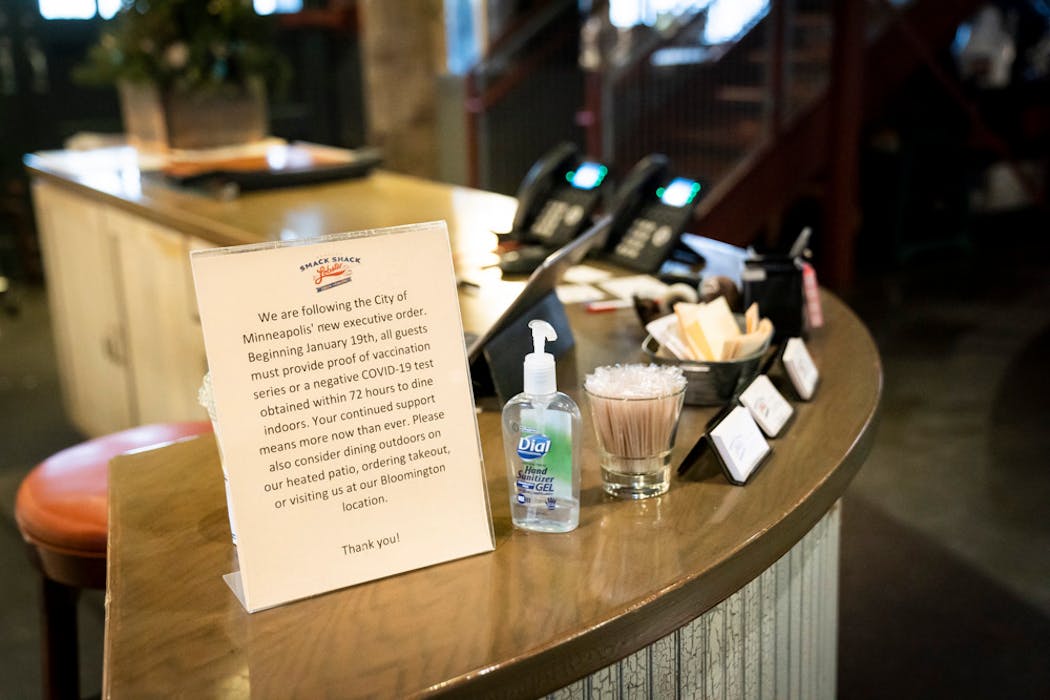 A sign about the mask and vaccination mandate is posted at the hostess desk at Smack Shack on Friday.