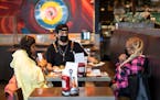 Server Luis Gonzalez brought food to Jasheena Bond and Erica Mooring on Friday at Smack Shack in Minneapolis. Owners of the restaurant were part of th