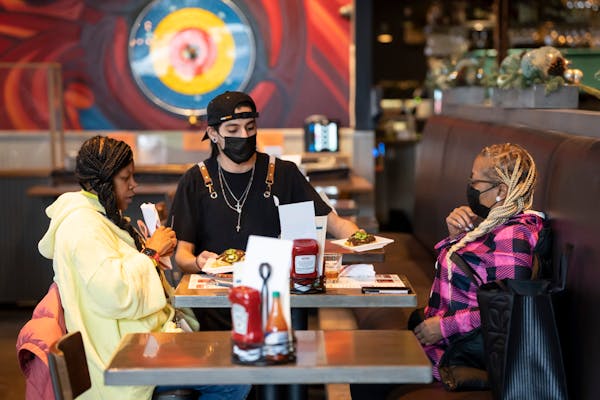 Server Luis Gonzalez brought food to Jasheena Bond and Erica Mooring on Friday at Smack Shack in Minneapolis. Owners of the restaurant were part of th