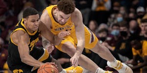 Iowa Hawkeyes forward Keegan Murray (15) left and Minnesota Gophers forward Jamison Battle (10) dive for a loose ball in the second half Jan. 16.