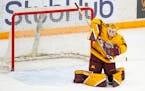 Minnesota goaltender Lauren Bench (35) makes a save against Wisconsin in the first period.