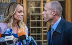 Adult film actress Stormy Daniels, left, stands with her lawyer Michael Avenatti during a news conference outside federal court in New York, April 16,