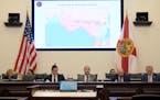 Florida Sen. Ray Rodrigues, center, views redistricting maps on a video monitor as an identical one is displayed behind him during a Senate Committee 