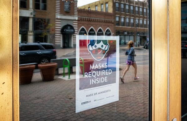 A storefront in downtown St. Cloud displayed mask requirement signs in May 2021.