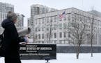A woman walks past the U.S. Embassy in Kyiv, Ukraine, Monday, Jan. 24, 2022. The State Department is ordering the families of all American personnel a