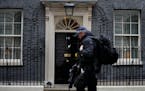 A police officer walks past 10 Downing Street in London, Tuesday, Jan. 25, 2022. London police say they are now investigating Downing Street parties d