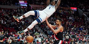 Anthony Edwards dunks over Portland Trail Blazers guard CJ McCollum during the second half. Edwards scored 14 of his 40 points in the fourth quarter.