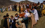 Relatives carry caskets toward a gravesite as they attend a mass funeral for members of a family killed in a U.S. drone airstrike, in Kabul, Afghanist
