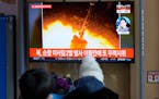 People watch a TV screen showing a news program reporting about North Korea’s missile launch with a file image, at a train station in Seoul, South K