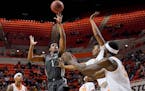 Iowa State guard Izaiah Brockington shoots in front of Oklahoma State guard Matthew-Alexander Moncrieffe, center, and Moussa Cisse in the first half 