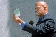 Gov. Jesse Ventura holds up a mock Minnesota sales tax rebate check in 1999.