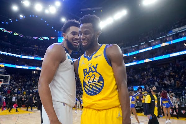 Timberwolves center Karl-Anthony Towns, left, laughs with Golden State forward Andrew Wiggins on Thursday night.