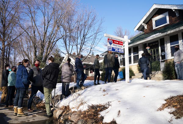 A line of several home shoppers and their real estate agents formed as they waited to view a home for sale in March 2021.