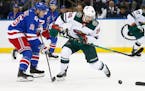 Minnesota Wild’s Mats Zuccarello controls the puck in front of New York Rangers’ Ryan Strome during the second period Friday night.