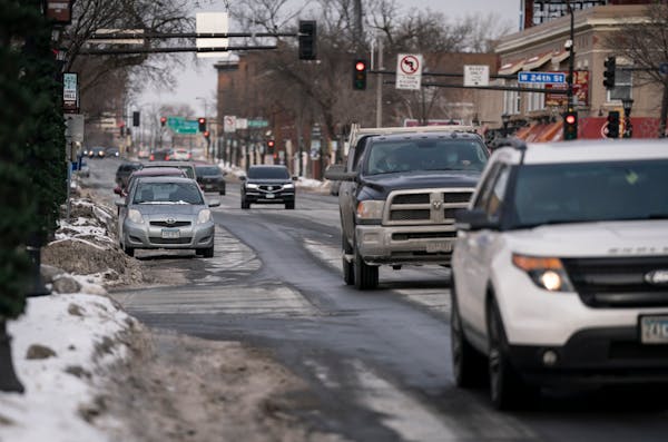 Vehicles parked along Hennepin Avenue near 24th Street in Minneapolis. Two plans call for slimming the corridor to one travel lane in each direction, 