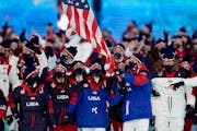 Brittany Bowe and John Shuster, right, of Chisholm, carries the U.S. flag with speedskater Brittany Bowe during the Olympic Opening Ceremony on Friday