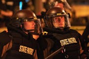 In May 2020, Minnesota State Patrol officers stood watch outside of the Third Precinct headquarters in Minneapolis. 