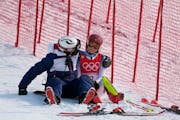 A team member consoles Mikaela Shiffrin after she skied out in the first run of the women’s slalom at the Winter Olympics on Wednesday.