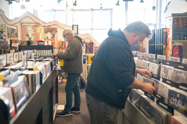 Tim Graf, left, and Adam Kooyer perused the vinyl Thursday at Down in the Valley in Golden Valley.