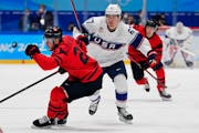 Canada’s Tyler Wotherspoon (23) chases the puck with United States’ Matt Knies (67) during a preliminary round men’s hockey game at the Olympics