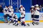 The United States team watches as Canada players celebrate after winning the women's gold medal hockey game at the 2022 Winter Olympics, Thursday, Feb