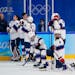 The United States team watches as Canada players celebrate after winning the women's gold medal hockey game at the 2022 Winter Olympics, Thursday, Feb