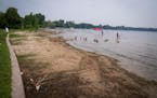 Visitors wade into White Bear Lake in July 2021, where the lake has receded from the shore at White Bear Lake County Park. 