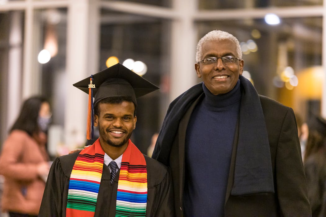 Abdi Bile, right, says nothing would have stopped him from seeing Mohamed Abdi Mohamed graduate from Macalester College in December. As a coach, Bile says, “You are responsible for these kids. In all aspects of their lives and growing up, you have to help them.” 