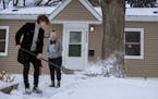 Kenley Johnson watched as her brother Benton Johnson shoveled outside her house in the Columbia Park neighborhood of Minneapolis, one of the most affo