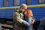 A couple embrace prior to the woman boarding a train carriage leaving for western Ukraine, at the railway station in Kramatorsk, eastern Ukraine, Sund