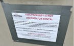 A sign taped to the office door at Victoria Townhomes in Brooklyn Center says, “This property is not licensed for rental.”