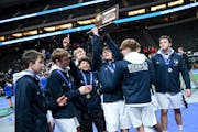 Jackson County Central wrestlers celebrate with their first place trophy during the Class 1A Minnesota High School Wrestling Team Championship between
