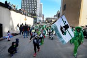 Ann Fryklund of St. Paul waved a flag in the 2019 St. Patrick’s Day parade in St. Paul. After a two-year COVID hiatus, the parade returns this year.