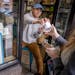Zach Vraa hands out pints of Gotham Crunch to a line of ice cream lottery winners who were able to purchase the treat at A to Z Creamery, in Hopkins.