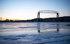 The Duluth aerial lift bridge was reflected in the ice on Lake Superior as the sun set over a frozen Lake Superior in 2021. 