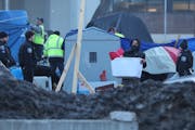 Minneapolis police and city workers surrounded the North Loop homeless encampment early Wednesday morning, closing streets with crime tape and metal b