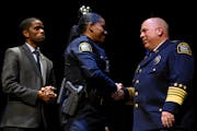 St. Paul Mayor Melvin Carter, left, watched as St. Paul Police Academy graduate Kristina Ijomah received her badge and a handshake from Police Chief T