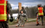 Minnesota National Guard Staff Sgt. Michael Walker carries a 150-pound human dummy while participating in the stress shoot during the Region IV Best W