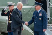 President Joe Biden greets Col. Matthew Jones, Commander of the 89th Airlift Wing, as he arrives on Marine One to board Air Force One at Andrews Air F