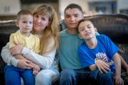 Olesia Zlochevska and her husband, Vova Zlochevskyi, hold their two boys, Roma, 5, left, and Artur, 9, at the home of Gina and Bill Nelson in Pelican