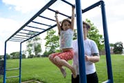 Iverson Otterson, 6, climbed across monkey bars with the help of her mother, Ericka, at Powderhorn Park in June 2020. 