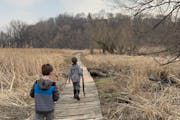 Brothers Kolton and Callen Wanous walk on a section of the floating trail at Mankato’s Rasmussen Woods in 2020.