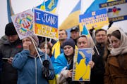 Oksana Shaw wiped away a tear while listening to a speaker talk about the plight of women and children in Ukraine, following a march of more than 100 