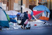 A former resident of a homeless encampment along Bloomington Avenue near 26th Street moved her belongings in January before city officials cleared the