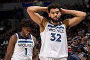 Anthony Edwards and Karl Anthony-Towns walk back to the bench after checking out of the game with their team down big in the fourth quarter Tuesday
