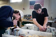Pine Technical and Community College automated systems technology students Chris Carty, right, and Wes Berens assemble control panels during class Mon