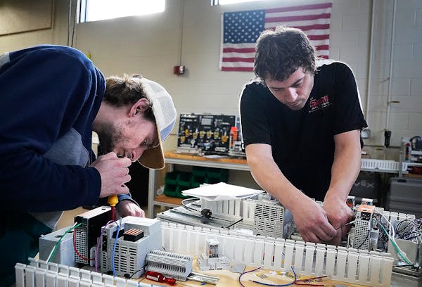 Pine Technical and Community College automated systems technology students Chris Carty, right, and Wes Berens assemble control panels during class Mon